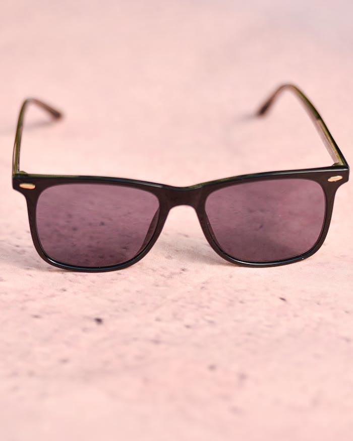 gallery-01 Trendy pink sunglasses displayed on a light pink textured surface for a fashionable look.